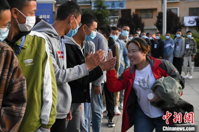 7月7日，拉薩三高考點外，領(lǐng)隊老師與考生擊掌鼓勁加油。　何蓬磊 攝