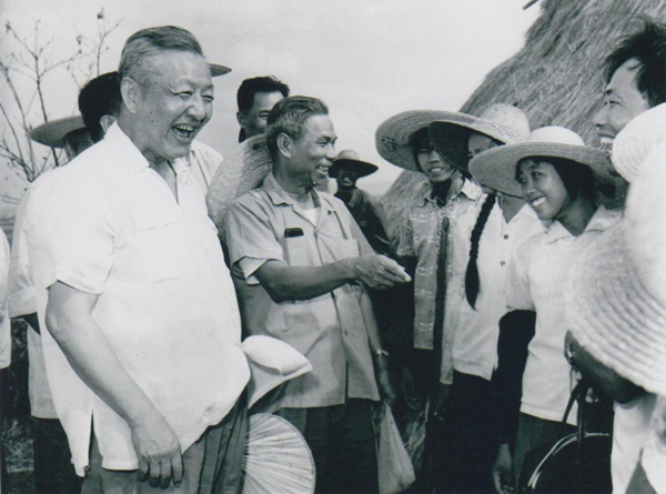 1980年8月底至9月初，習(xí)仲勛（左一）在廣東湛江農(nóng)村視察時(shí)與青年親切交談。